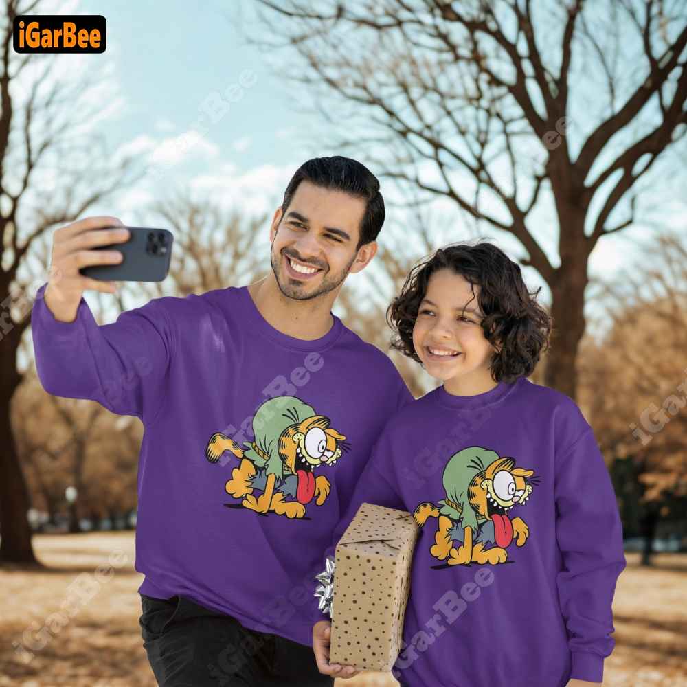 Father and son wearing matching purple Garfield sweatshirts with cute Garfield image, kids' size L.