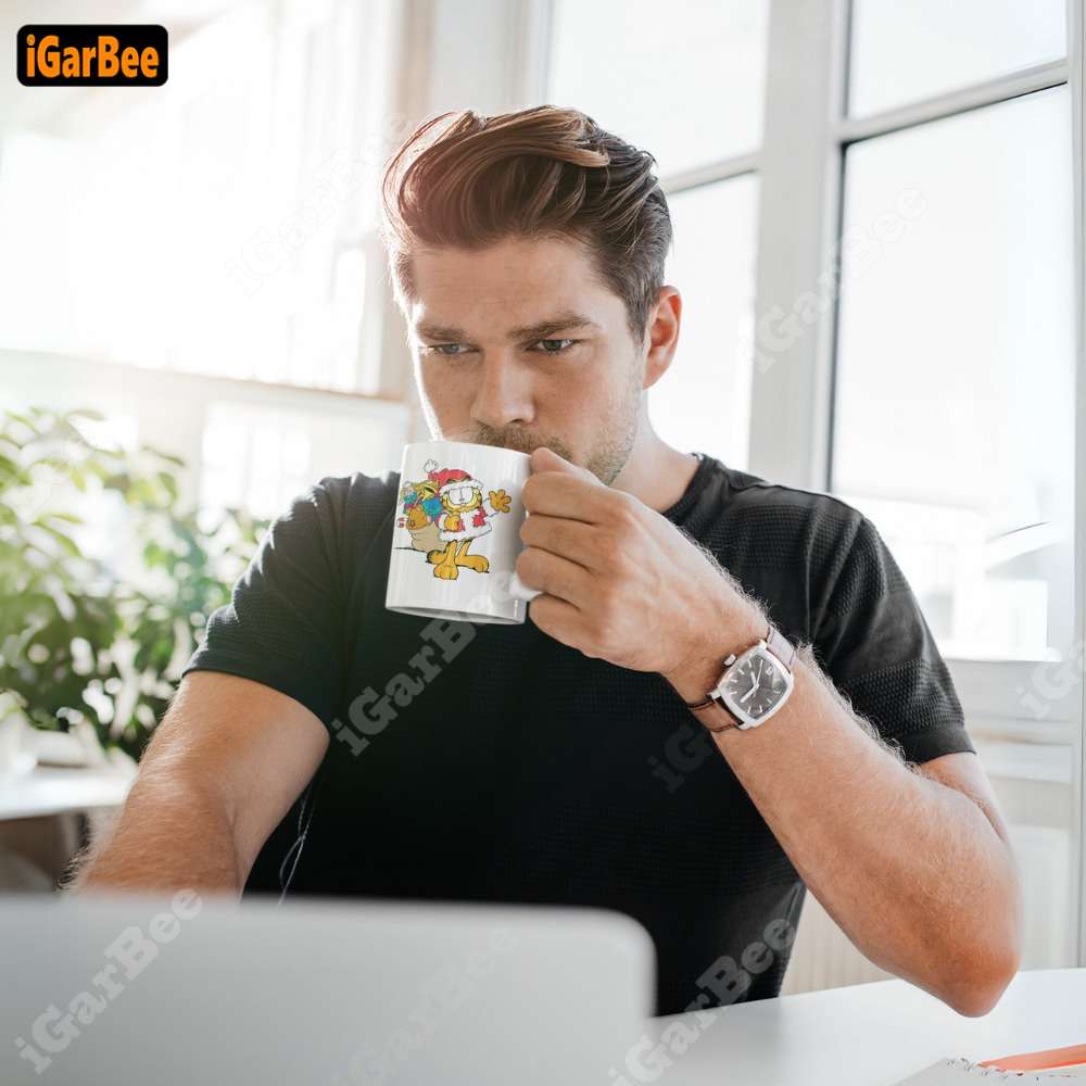 he is using a white ceramic garfield mug from igarbee while working Father's Day present ideas with Garfield mug